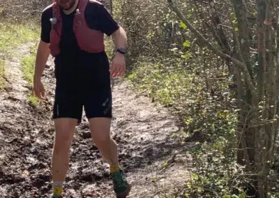 Homme courant sur un sentier boueux