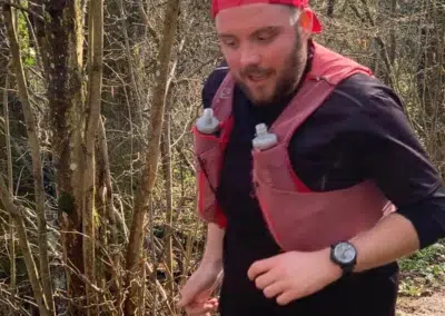 Coureur en forêt avec gilet d'hydratation